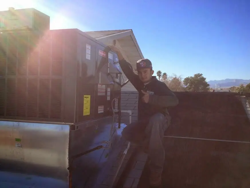 HVAC technician performing Boiler Repair on a rooftop unit in Sudbury